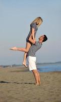 heureux jeune couple s'amuser sur la plage photo