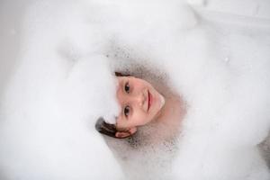 vue de dessus de la petite fille dans le bain jouant avec de la mousse photo