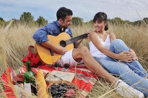 couple heureux profitant d'un pique-nique à la campagne dans l'herbe haute photo