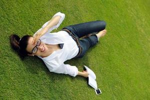 jeune femme lisant un livre dans le parc photo