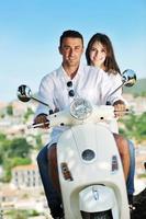 portrait of happy young love couple on scooter profitant de l'heure d'été photo