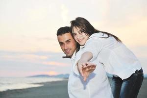 heureux jeune couple s'amuser sur la plage photo