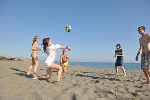 un groupe de jeunes s'amuse et joue au beach-volley photo