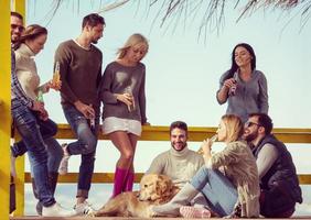 groupe d'amis s'amusant le jour de l'automne à la plage photo