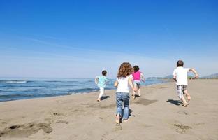 groupe d'enfants heureux jouant sur la plage photo