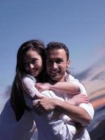 jeune couple sur la plage s'amuser photo