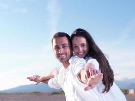 jeune couple sur la plage s'amuser photo