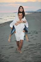 heureux jeune couple s'amuser sur la plage photo