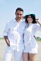 heureux jeune couple s'amuser sur la plage photo