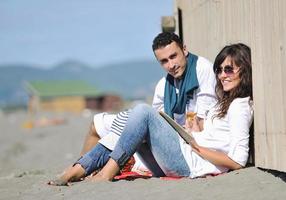 jeune couple profitant d'un pique-nique sur la plage photo