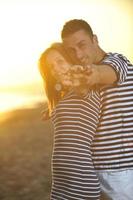 un jeune couple heureux passe un moment romantique sur la plage photo