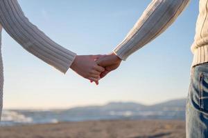 jeune couple aimant sur une plage à la journée ensoleillée d'automne photo