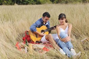 couple heureux profitant d'un pique-nique à la campagne dans l'herbe haute photo