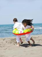 groupe d'enfants heureux jouant sur la plage photo