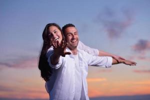 jeune couple sur la plage s'amuser photo