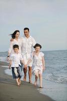 jeune famille heureuse s'amuser sur la plage photo