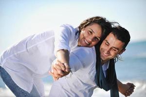 heureux jeune couple s'amuser sur la belle plage photo