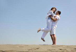 heureux jeune couple s'amuser sur la plage photo