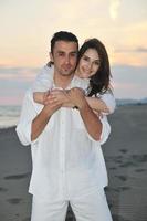 heureux jeune couple s'amuser sur la plage photo