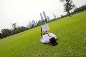 jeune femme lisant un livre dans le parc photo