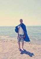 drôle de super-héros debout sur la plage photo