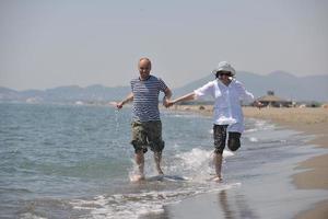 heureux jeune couple s'amuser sur la plage photo