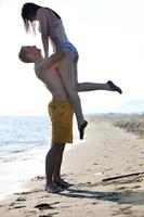 heureux jeune couple s'amuser sur la plage photo