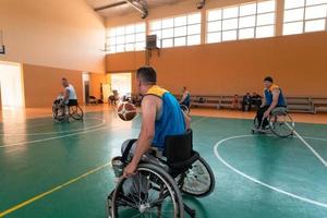 Anciens combattants handicapés de guerre mixtes et équipes de basket-ball d'âge en fauteuil roulant jouant un match d'entraînement dans une salle de sport. concept de réadaptation et d'inclusion des personnes handicapées photo