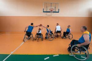 Anciens combattants handicapés de guerre mixtes et équipes de basket-ball d'âge en fauteuil roulant jouant un match d'entraînement dans une salle de sport. concept de réadaptation et d'inclusion des personnes handicapées photo