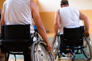 photo en gros plan de fauteuils roulants et d'anciens combattants handicapés jouant au basket-ball sur le terrain