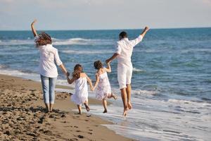 jeune famille heureuse s'amuser sur la plage photo