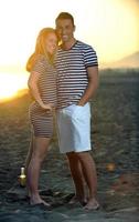 heureux jeune couple s'amuser sur la plage photo