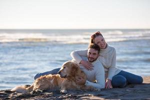 couple avec chien profitant du temps sur la plage photo