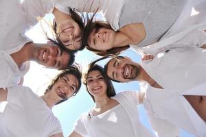 groupe de jeunes heureux en cercle à la plage photo