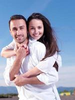 jeune couple sur la plage s'amuser photo