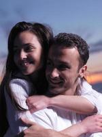 jeune couple sur la plage s'amuser photo