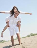 heureux jeune couple s'amuser sur la plage photo