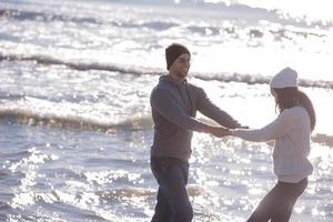 jeune couple aimant sur une plage à la journée ensoleillée d'automne photo