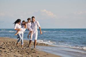 jeune famille heureuse s'amuser sur la plage photo