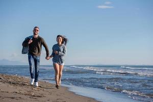 jeune couple aimant sur une plage à la journée ensoleillée d'automne photo