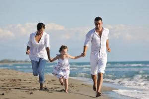 jeune famille heureuse s'amuser sur la plage photo