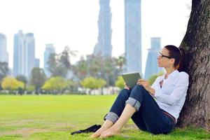 belle jeune femme avec tablette dans le parc photo