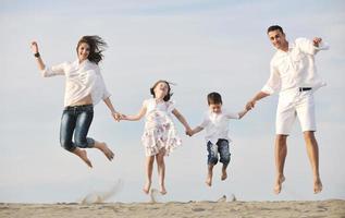 jeune famille heureuse s'amuser sur la plage photo