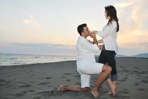 heureux jeune couple s'amuser sur la plage photo