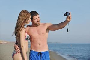 heureux jeune couple amoureux prenant des photos sur la plage