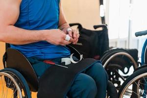 un basketteur handicapé met un corset et des bandages sur ses bras et ses doigts en vue d'un match dans l'arène photo