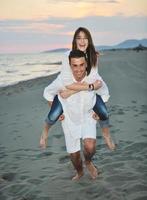 heureux jeune couple s'amuser sur la plage photo