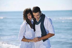 heureux jeune couple s'amuser sur la belle plage photo