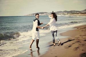 heureux jeune couple s'amuser sur la belle plage photo