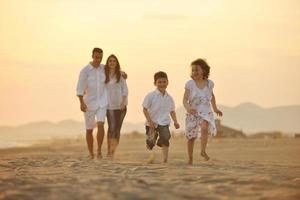 jeune famille heureuse s'amuser sur la plage au coucher du soleil photo